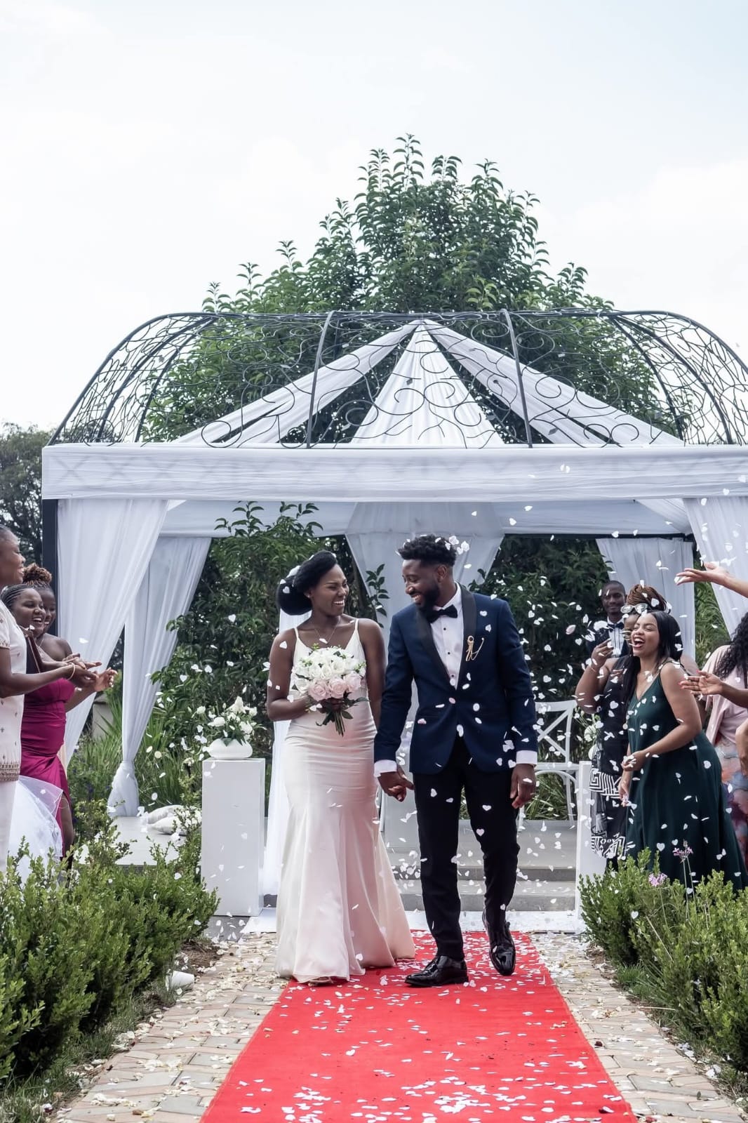Bride and groom celebrating with confetti under a wrought-iron gazebo at Tshedza Gardens, Muano Functions Venue