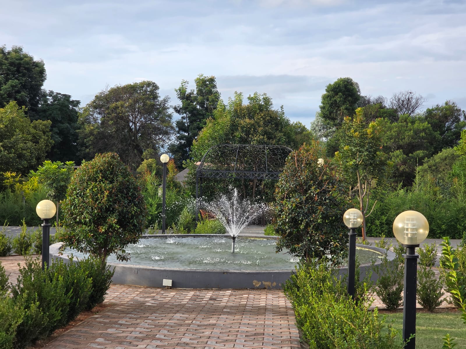 Tshedza Gardens fountain setting with wrought-iron gazebo, manicured hedges and garden lighting