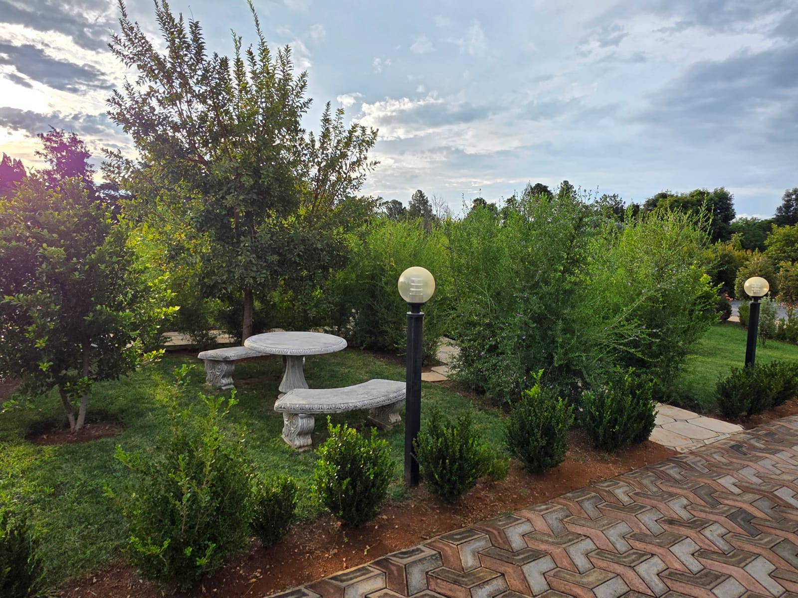 Tshedza Gardens intimate seating nook with a stone table and benches among the trees